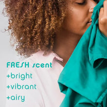 Woman smelling vibrant teal fabric highlighting Downy Unstopables scent booster beads with fresh bright airy scent
