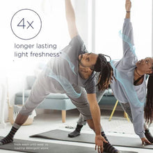 Two people doing yoga indoors with 4x longer lasting light freshness from Downy Ocean Mist scent booster beads