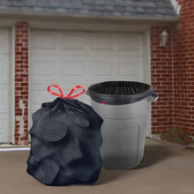Black tied garbage bag with red drawstring next to gray outdoor trash can by garage 33 gallon drawstring trash bags